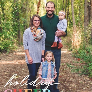 May include: A family of four standing in a wooded area. The parents are smiling and holding their two young daughters. The text "holiday CHEER from THE MILLER'S" is written in colorful letters at the bottom of the image.