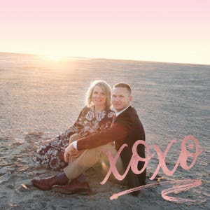 May include: A couple sits on a sandy beach at sunset, smiling at the camera. The word "xoxo" is written in pink script in the foreground.