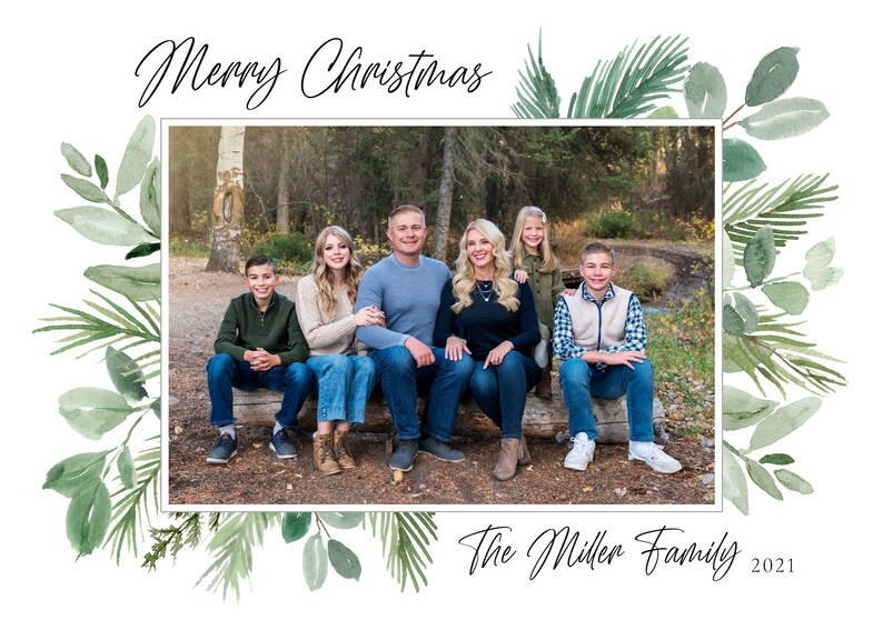 May include: A Christmas card featuring a family of six posing in a forest setting. The card has a green watercolor border with leaves and branches. The text "Merry Christmas" is at the top of the card and "The Miller Family 2021" is at the bottom.