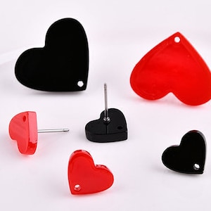 Könnte beinhalten: Ein Set mit vier herzförmigen Ohrringen, zwei roten und zwei schwarzen. Die Ohrringe sind aus Acryl und haben ein schlichtes, minimalistisches Design.