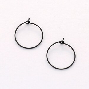 May include: A pair of black hoop earrings. The earrings are simple and minimalist in design.