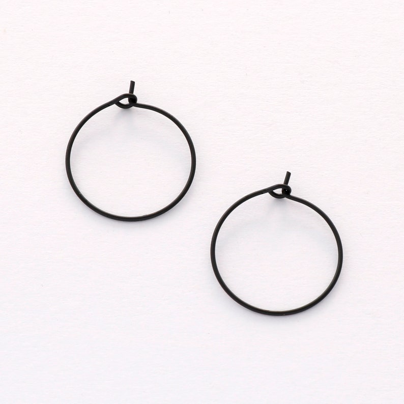 May include: A pair of black hoop earrings. The earrings are simple and minimalist in design.