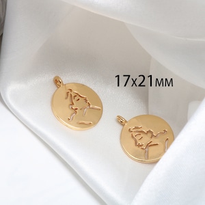 Peut inclure: Deux breloques en métal doré avec un motif découpé d'un visage. Les breloques mesurent 17 x 21 mm.