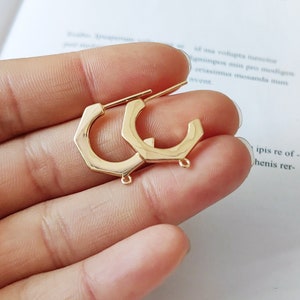 Può includere: Un paio di orecchini a cerchio esagonali dorati con un anello di giunzione su ogni orecchino.