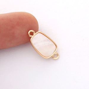 May include: Gold-toned connector with a white rectangular stone. The connector has two loops on either side.
