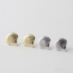 May include: Four gold and silver seashell shaped charms with a loop for attaching to jewelry or other crafts.