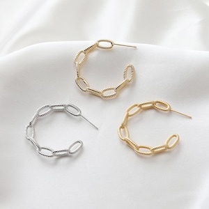 May include: Two pairs of hoop earrings, one gold and one silver, made of linked oval shapes.