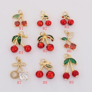Puede incluir: Colección de nueve colgantes de cereza dorados con cuentas de cereza rojas y hojas verdes. Algunos colgantes presentan piedras preciosas claras o rojas. Cada colgante tiene un lazo para sujetar. Numerados del #1 al #9.