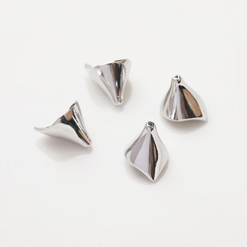 Peut inclure: Quatre embouts de perles en m&eacute;tal argent&eacute; en forme de c&ocirc;ne avec un trou en haut. Les embouts de perles sont brillants et ont une surface lisse.