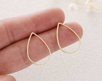 May include: Two gold-colored, teardrop-shaped earring components. Each earring is a delicate outline, with a smooth, polished finish. The earrings are displayed against a neutral background, highlighting their simple elegance. These components are ideal for DIY jewelry projects.