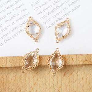 May include: Four gold-toned connector charms with clear faceted glass stones. Each charm has two loops for attaching to jewelry.