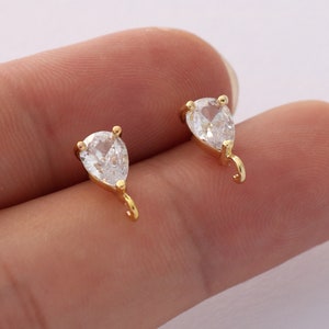 Puede incluir: Dos abalorios de forma de lágrima de tono dorado con acentos de cristal transparente. Cada abalorio tiene un bucle para sujetarlo a una joya.