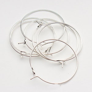 May include: A set of six silver hoop earrings. The hoops are all the same size and have a simple, elegant design.