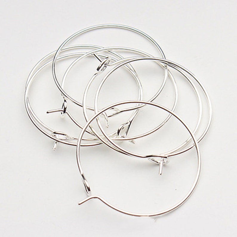 May include: A set of six silver hoop earrings. The hoops are all the same size and have a simple, elegant design.
