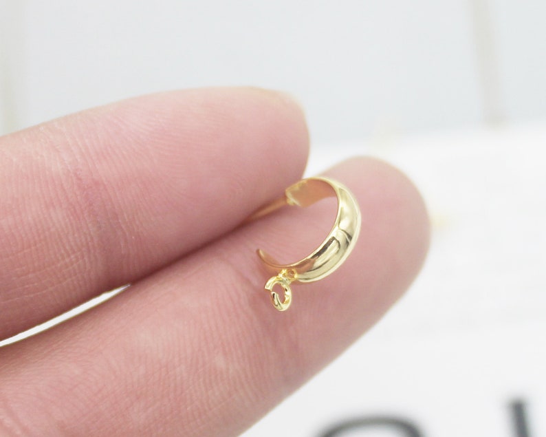May include: Gold-toned metal pendant bail with a smooth, rounded shape and a small loop at the top.