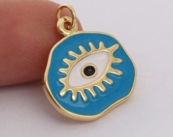 Puede incluir: Encanto dorado con fondo de esmalte azul y un diseño de ojo mal de ojo blanco. El ojo tiene una pupila negra.