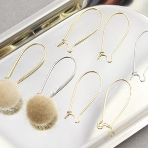 Può includere: Sei paia di cerchietti per orecchini in oro e argento con pompon morbidi marroni.