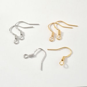 May include: A set of six earring hooks, three gold and three silver. The hooks are made of metal and have a spring-loaded closure.