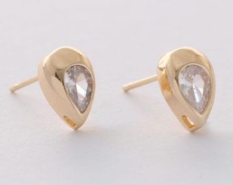 May include: A pair of gold teardrop-shaped earrings with clear cubic zirconia stones.