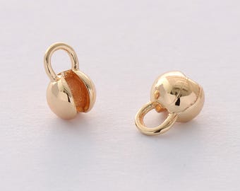 May include: Two gold-toned metal bead caps with a loop on top. The bead caps are round and have a smooth finish.