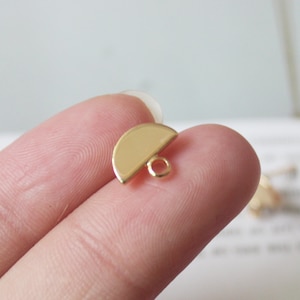 May include: Gold-toned metal half-circle charm with a loop for attaching to jewelry or other crafts.