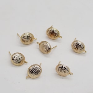 May include: Six gold-toned earring findings with a textured, rounded top and a post for attaching earrings.