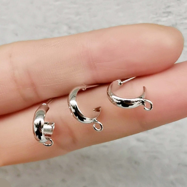 May include: Three silver-toned metal jump rings with a loop on one side. The rings are approximately 1 inch in diameter.