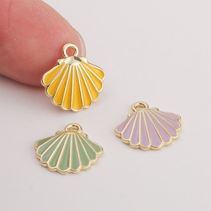 May include: Three gold-tone metal charms shaped like seashells. The shells are enameled in different colors: yellow, purple, and green.