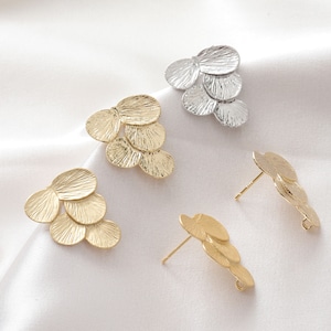 May include: Three pairs of earrings with a layered leaf design. The earrings are available in gold and silver.