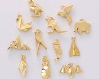 May include: A collection of gold-colored origami-style charms in various shapes, including a flamingo, swan, kangaroo, bird, elephant, hummingbird, seahorse, paper airplane, diamond, pineapple, and bat. Each charm has a small loop for attaching to jewelry.