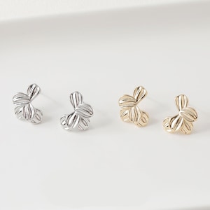 May include: Three pairs of flower-shaped earrings. The earrings are made of metal and come in silver, gold, and rose gold.