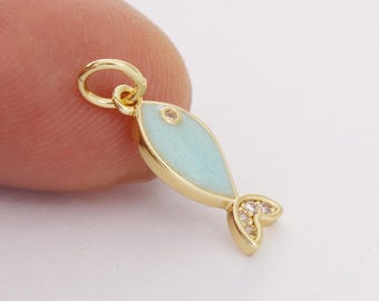 May include: Gold-tone charm featuring a light blue enamel fish with clear crystal accents on the tail.