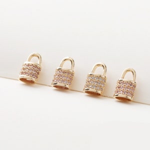 May include: Four gold padlock charms with clear and pink crystal embellishments. The charms are ideal for adding a touch of sparkle to jewellery projects.