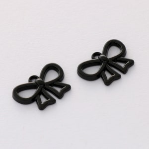 Könnte beinhalten: Zwei schwarze Metall-Schleifen-Anhänger mit einem Loch zum Anbringen an Schmuck oder anderen Bastelarbeiten.