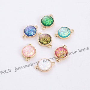 May include: Assortment of seven round, gold-toned metal charms with a variety of iridescent glitter colours. Each charm has two jump rings for attaching to jewellery.