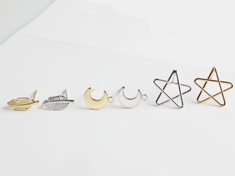 Puede incluir: Seis hallazgos para pendientes en varias formas, incluyendo una pluma, una luna creciente y una estrella. Los hallazgos est&aacute;n hechos de metal plateado y dorado.