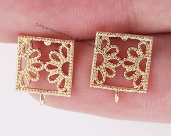 May include: Two gold-tone metal earring blanks with a square shape and a delicate floral design. Each blank has a small loop at the bottom for attaching earring findings.
