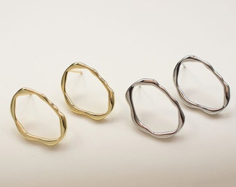 May include: A pair of earrings with an irregular oval shape. One pair is gold and the other is silver.
