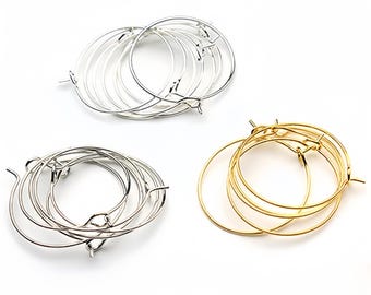 May include: A set of six hoop earrings, three silver and three gold, with a simple, circular design. The earrings are made of metal and have a smooth finish.