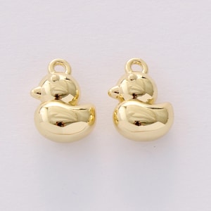 Puede incluir: Dos dijes dorados con forma de pato. Cada dije tiene un lazo en la parte superior para sujetarlo a una joya. Los patos tienen un cuerpo redondeado, un pico pequeño y una cabeza detallada. Ideal para crear pendientes, collares o pulseras.