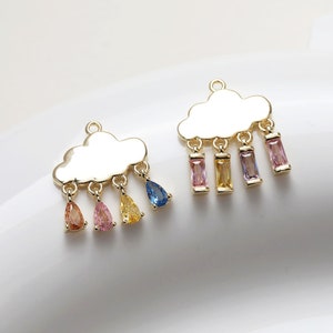 May include: Two gold-tone cloud charms with dangling colourful crystal drops. The charms are perfect for jewellery making or adding a whimsical touch to crafts.