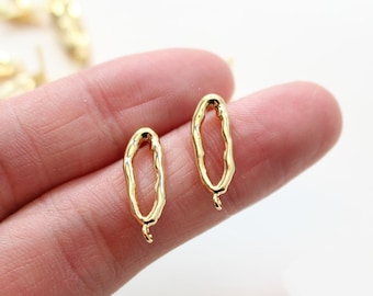 May include: Two gold-toned oval-shaped metal jump rings with a textured surface. The jump rings have a small loop at the bottom.