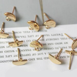 May include: Eight gold-toned earring posts with half-circle shaped tops. The posts are designed for use with jewelry making.