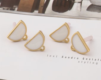 May include: Three gold-toned half-circle charms with white enamel. Each charm has a small loop at the bottom.
