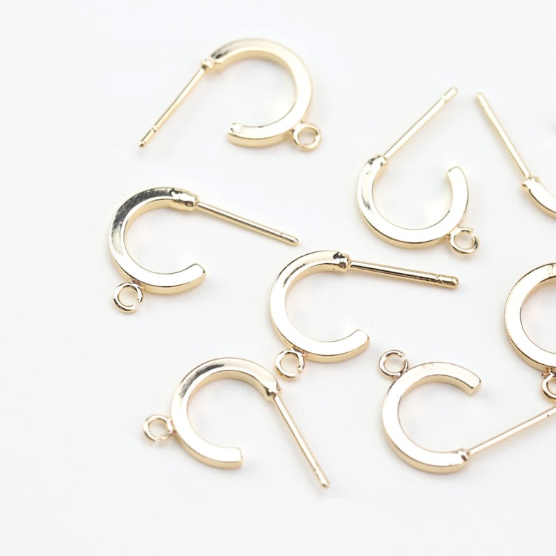 Puede incluir: Un conjunto de ocho aros de pendientes dorados con un anillo de salto y un poste para sujetar un cierre de pendiente. Los aros tienen un di&aacute;metro de aproximadamente 3,8 cm.