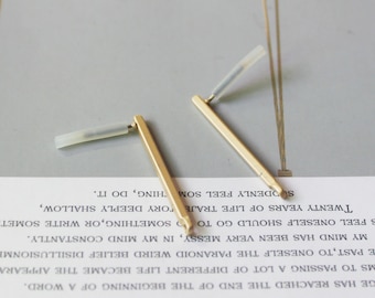 May include: Two gold metal pen nibs with clear plastic handles. The nibs are on a white surface with text.