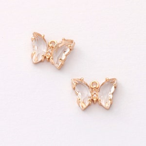 May include: Two gold-tone butterfly charms with clear crystal wings and clear rhinestone accents.