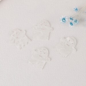 Puede incluir: Cuatro adornos blancos en forma de fantasma con una superficie texturizada.