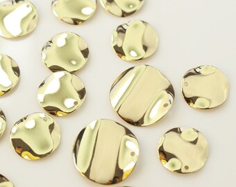 May include: A collection of gold-toned metal circle charms with a hammered texture. Each charm has a small hole for attaching to jewelry or other crafts.
