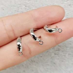 May include: Three silver hoop earring findings with a jump ring attached to each hoop.